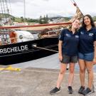 Priya Talreja smiles alongside another participant in front of the tall ship named Oosterschelde in the Azores.