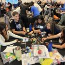 A group of high school students sit around a table and sort colorful Lego bricks during a team activity at the UC Davis ARC Ballroom.